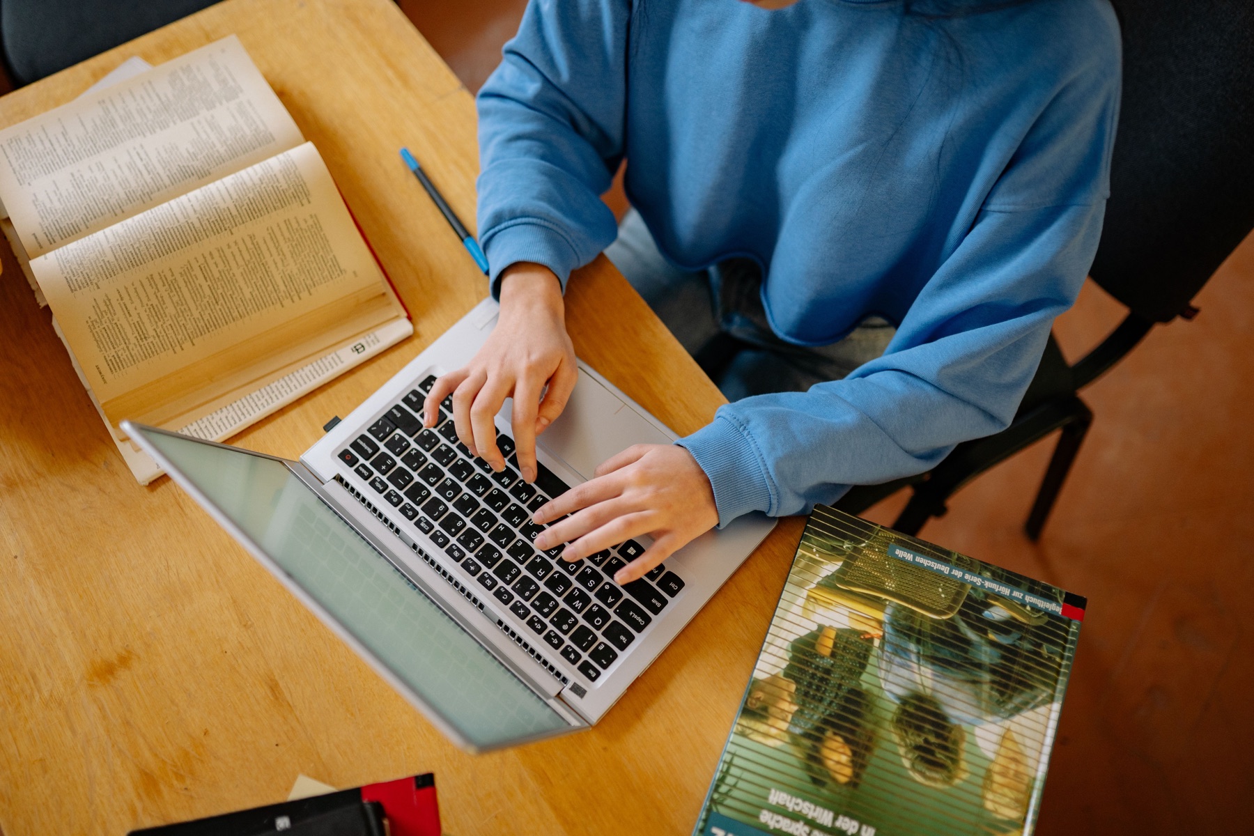 Student studying with a laptop and books
